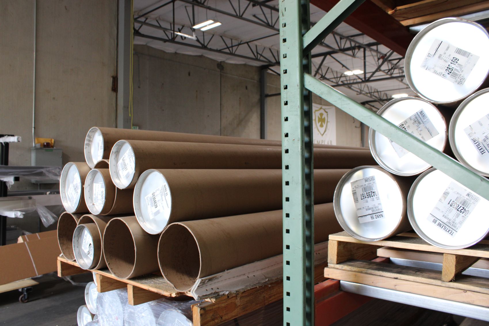 Rolls of screen fabric stock on the shop floor