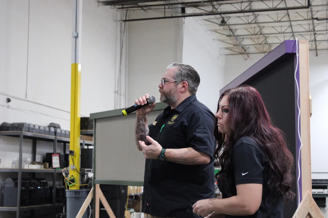 Templar staff leading a dealer training session with a demo screen in the warehouse